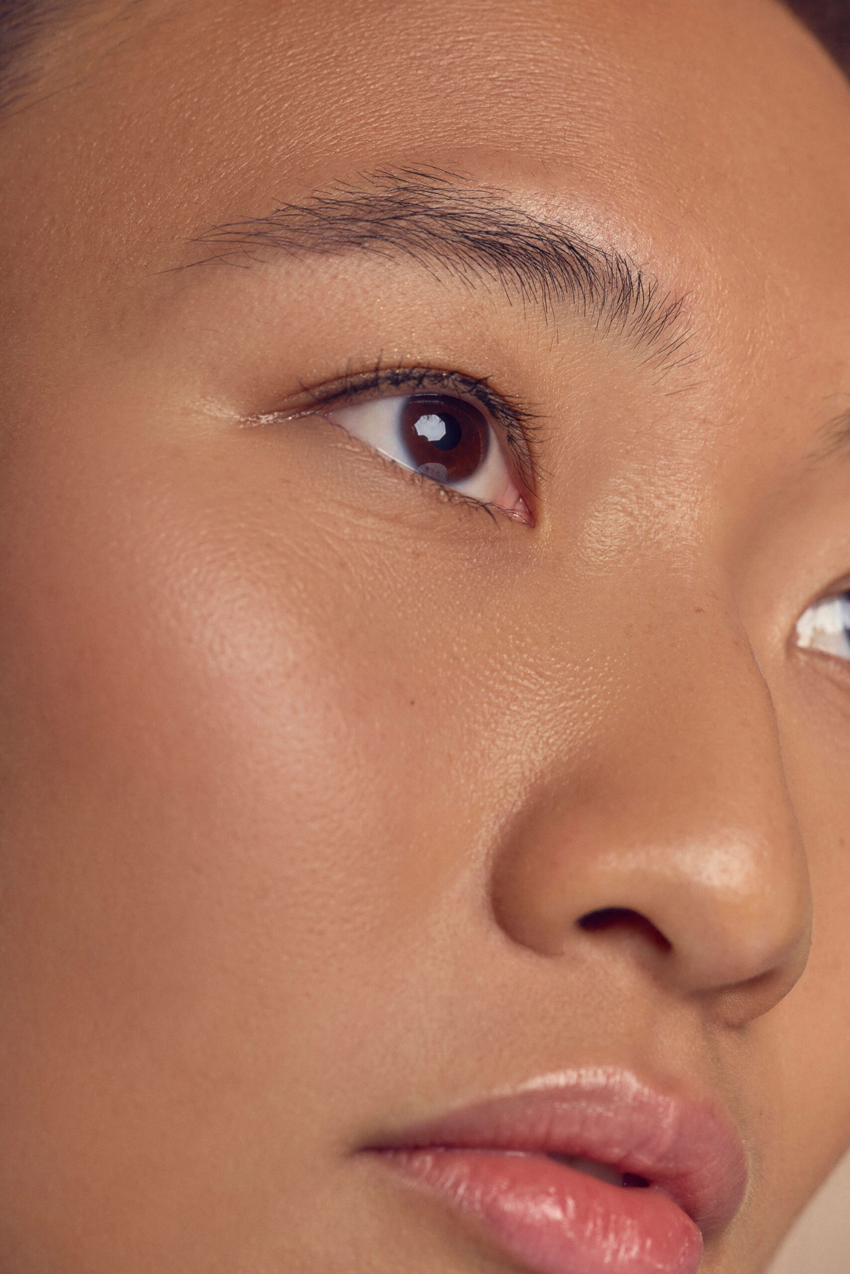 Close-up of a person’s face showing smooth, clear skin with minimal makeup. The focus is on the eye and surrounding skin, highlighting natural beauty and a fresh complexion.